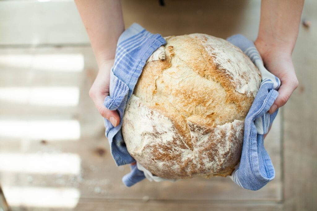 homemade artisan bread wrapped in a blue towel