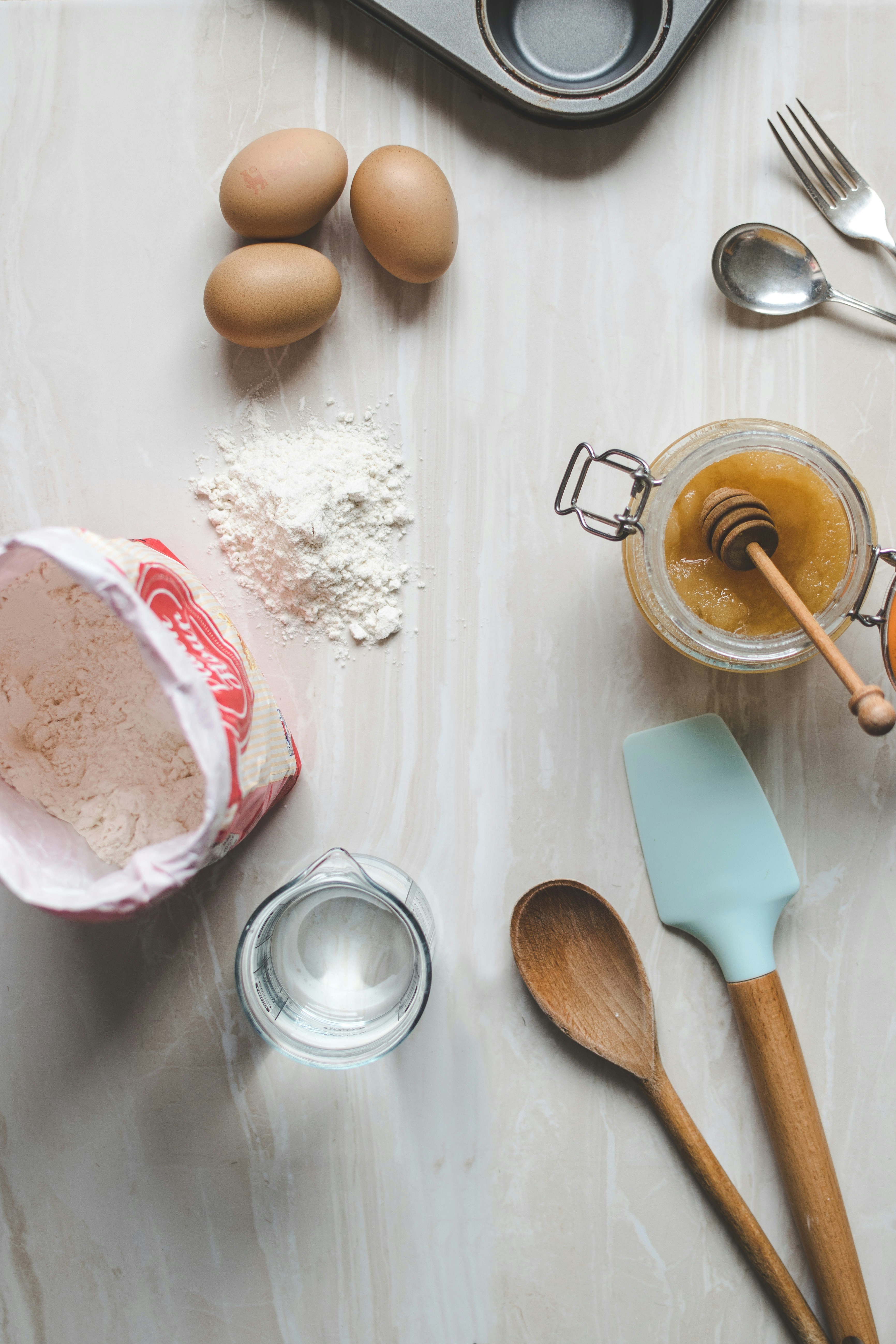 eggs, flour, honey, and baking equipment on a table