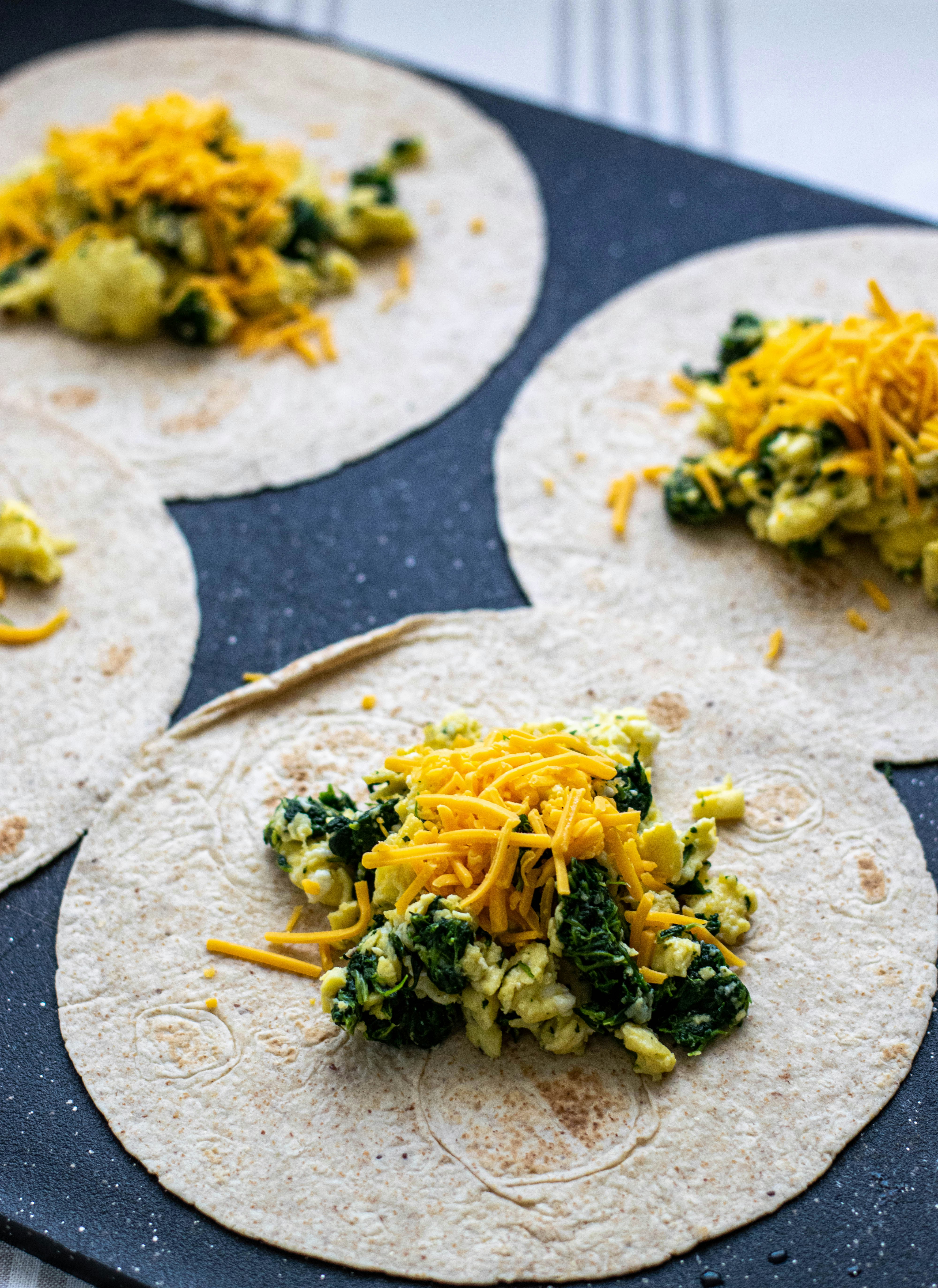 tortillas with eggs and spinach and cheese on top
