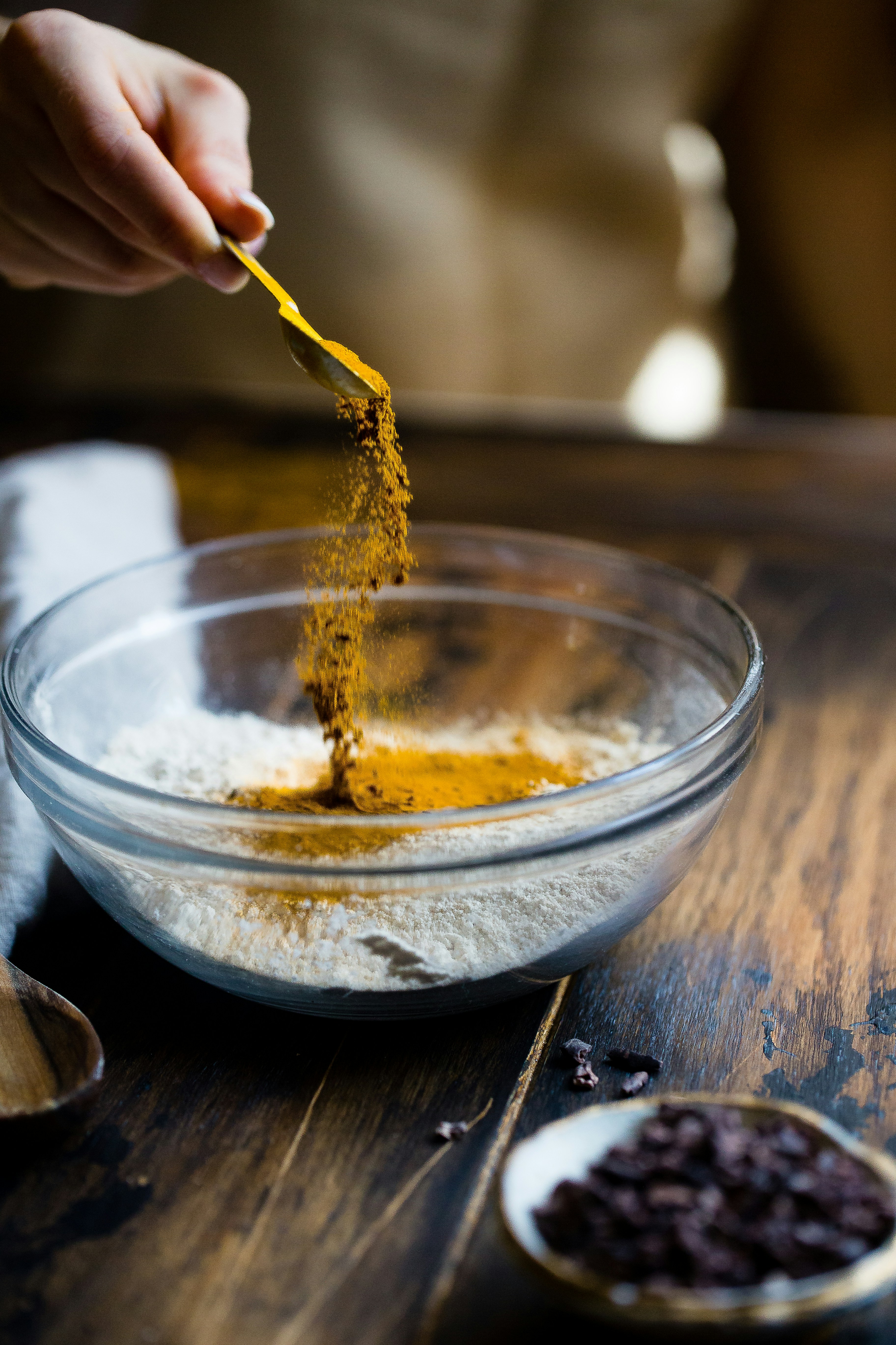 seasonings being added to a small glass bowl